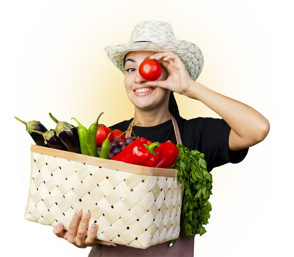 Jeune femme jardinier tablier chapeau tenant panier plein legumes tomates pres son oeil souriant